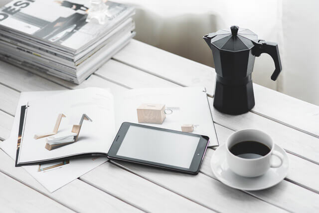 白い机の上のコーヒーカップとデジタルタブレット
